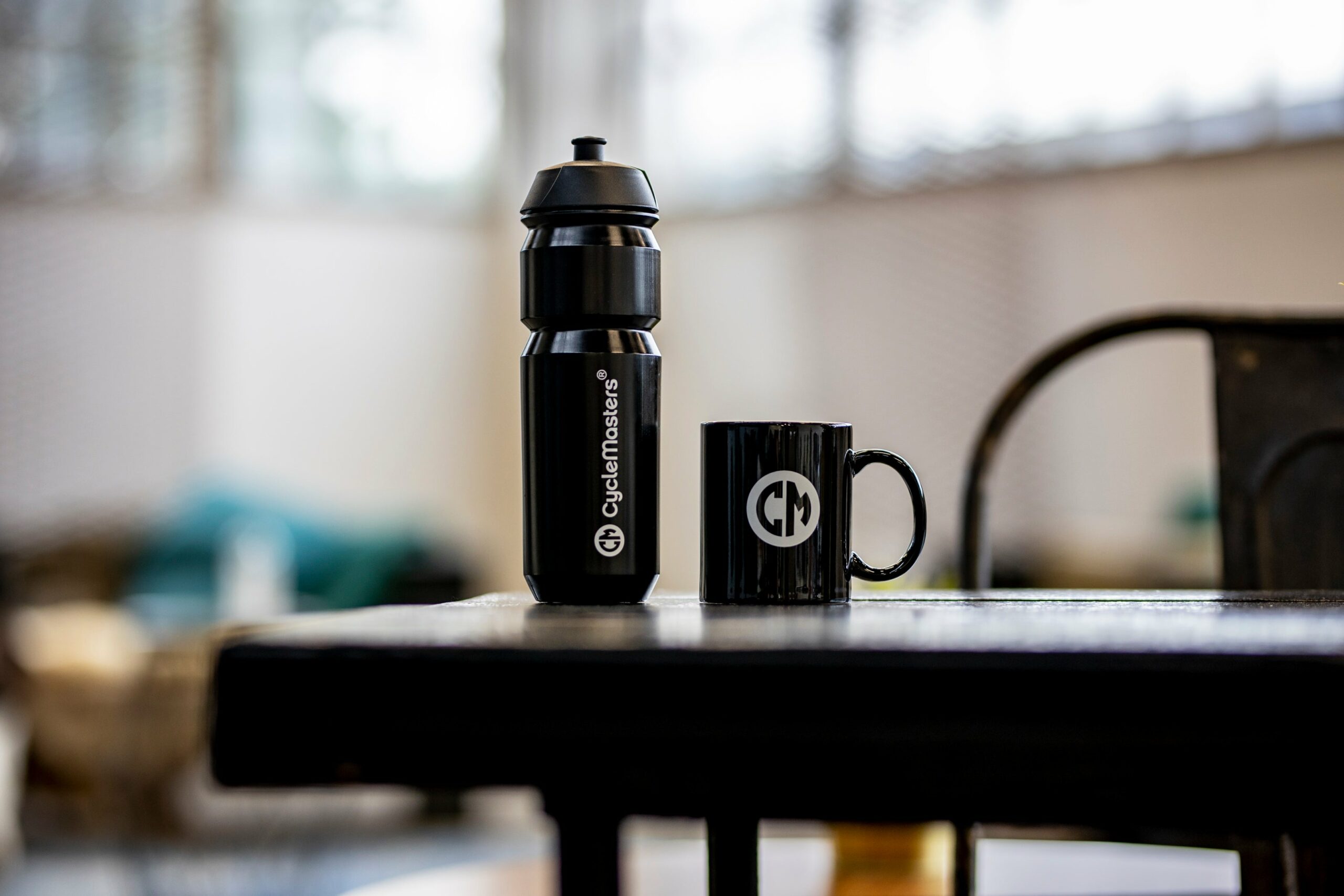A black CycleMasters bottle and mug