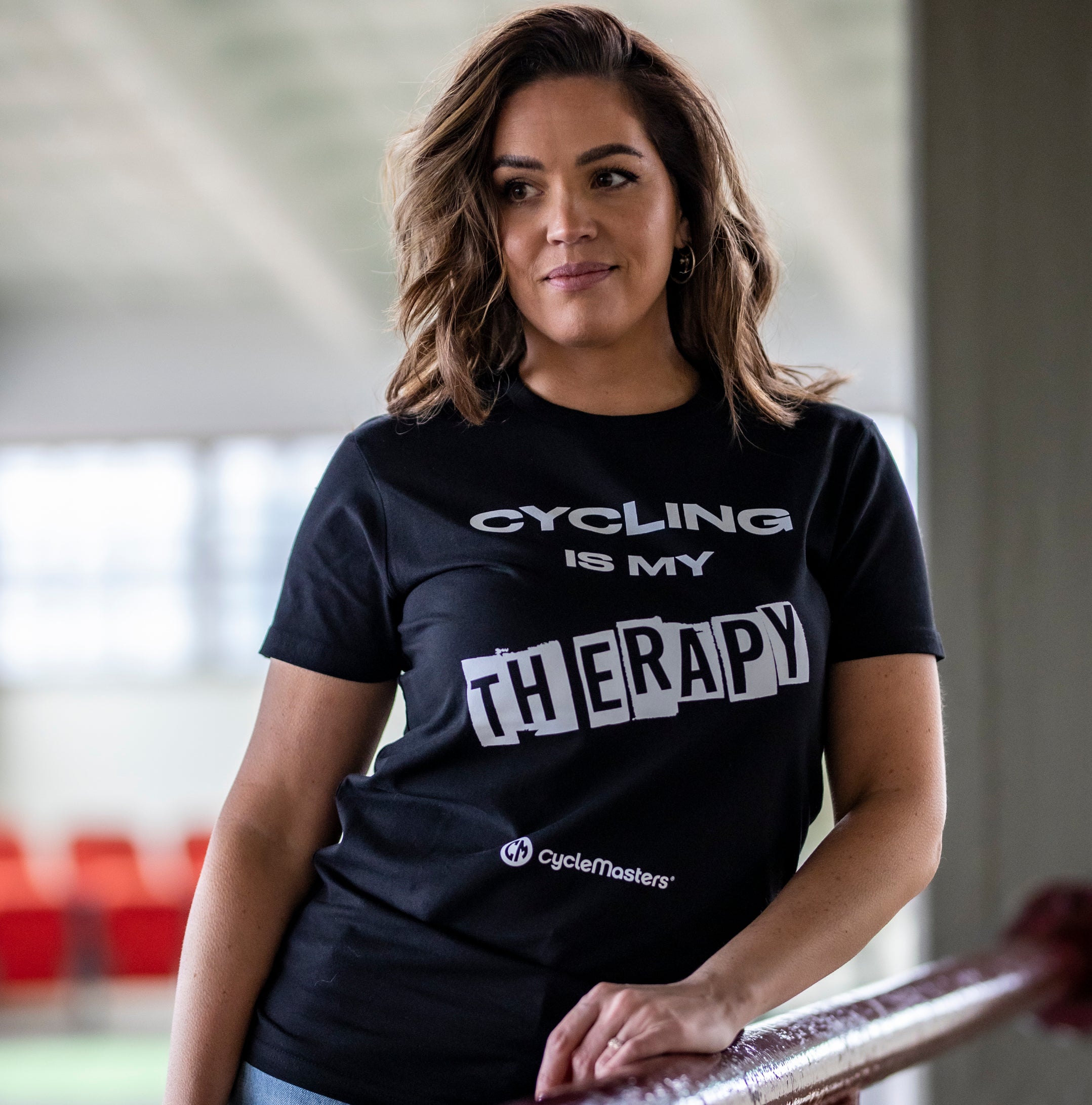 A woman wears a black CycleMasters t-shirt 