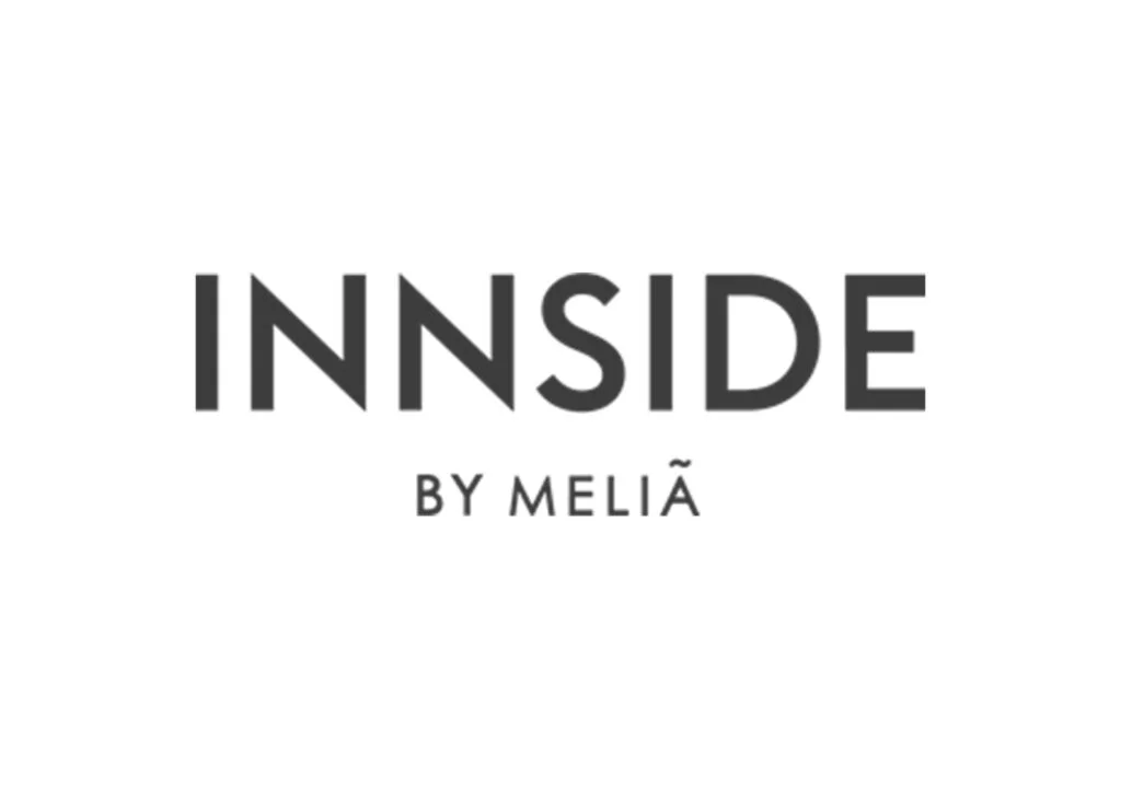 Logo van "innside by meliá", met vetgedrukte hoofdletters en de zinsnede "by meliá" eronder, gemarkeerd met een tilde-symbool boven de letter 'i' in "innside.